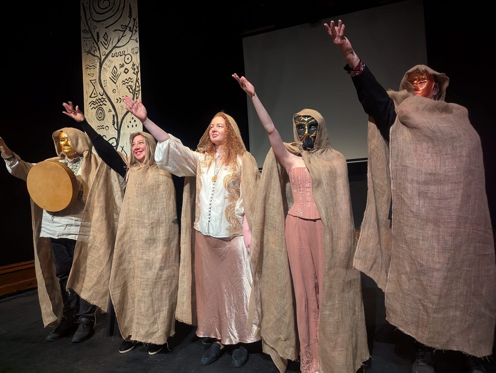 The cast of Trypillian Tarot with arms raised in celebration at the end of the performance.