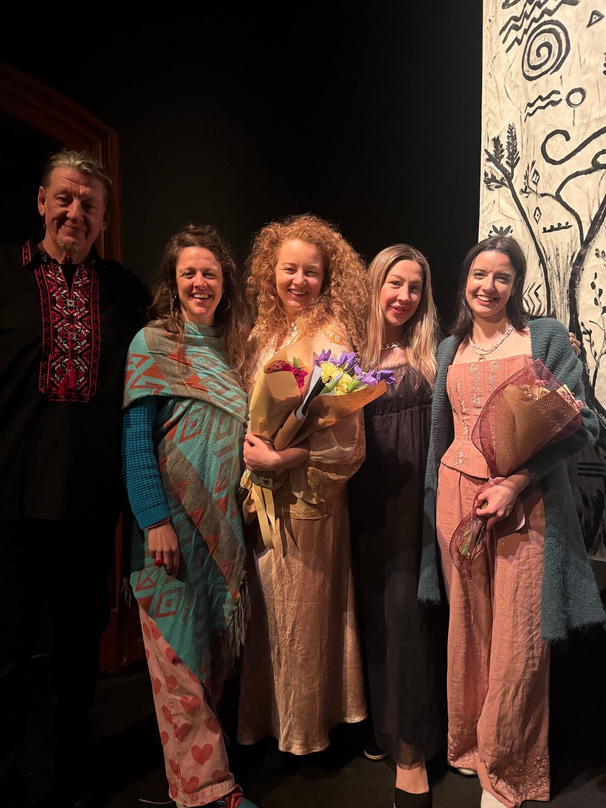 The five performers of Trypillian Tarot together after the show, holding bouquets and smiling.